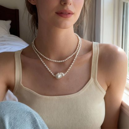 Woman wearing a pearl necklace in a bedroom setting
