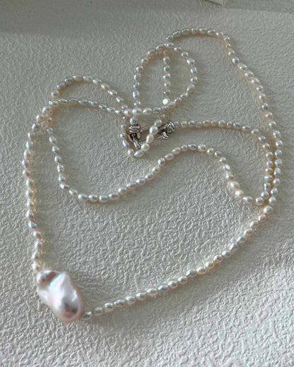 Pearl necklace on a textured white surface