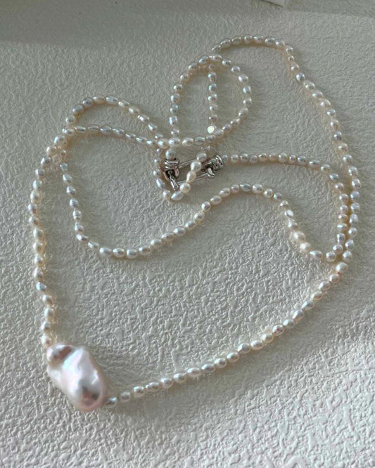 Pearl necklace on a textured white surface
