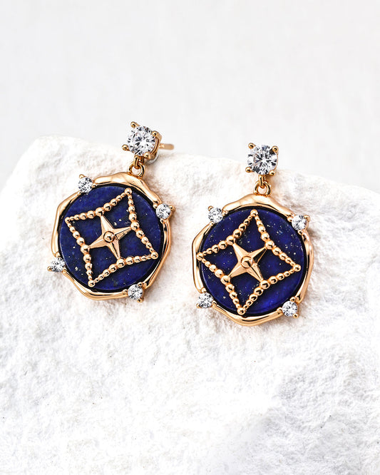 Pair of gold and blue earrings on a white background