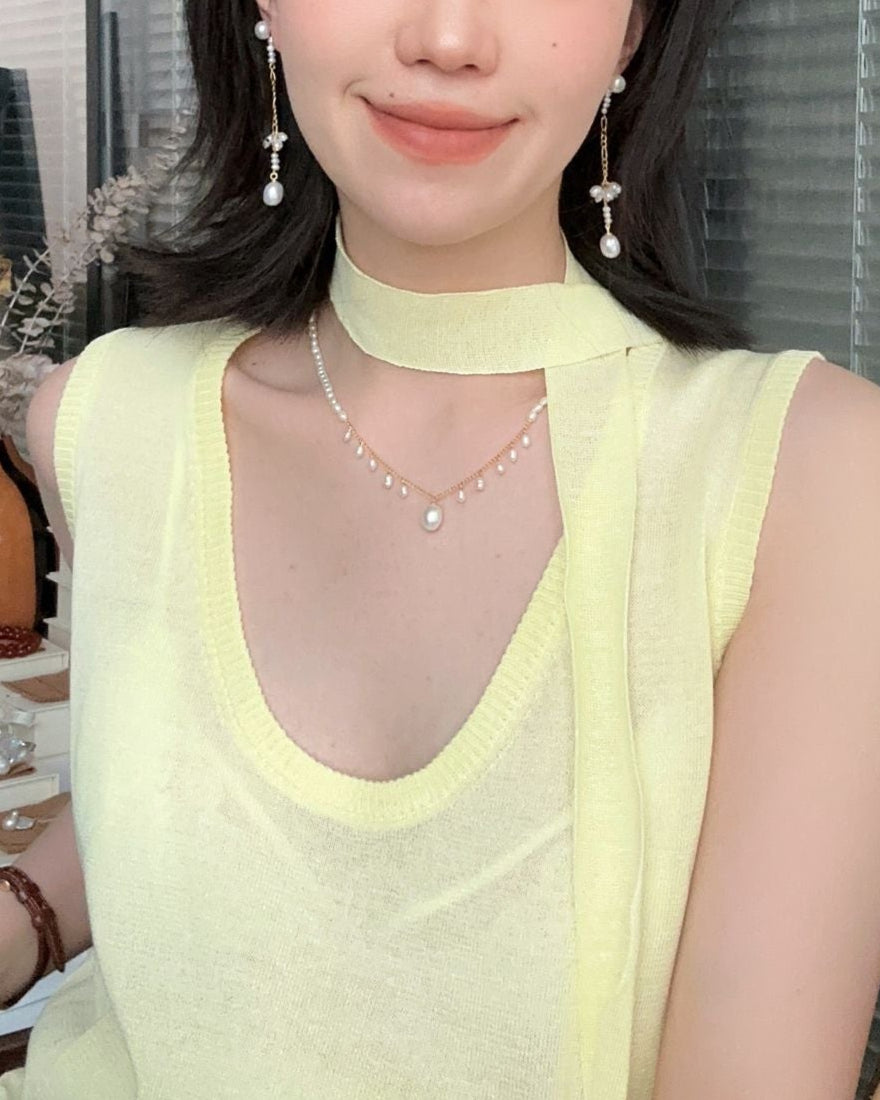 Woman wearing a light green sleeveless top with a blurred background