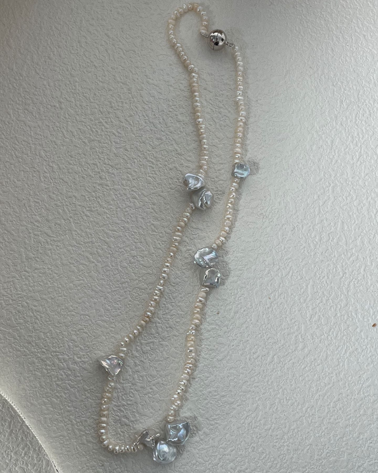 Necklace with heart-shaped crystals on a light gray background
