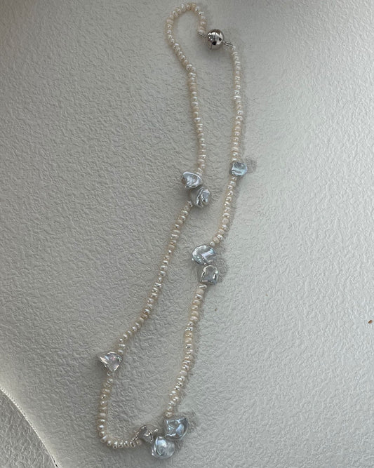 Necklace with heart-shaped crystals on a light gray background