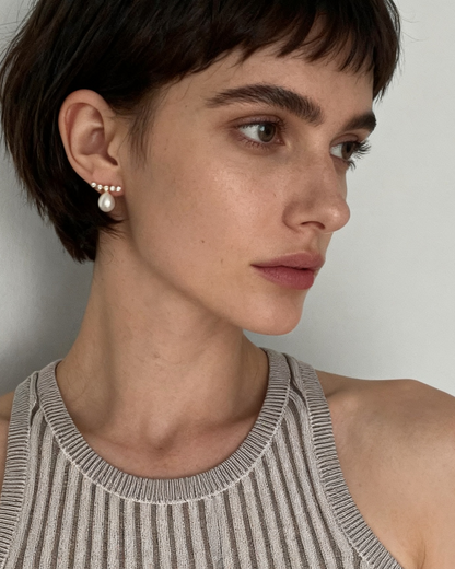 Woman wearing a striped tank top against a plain background