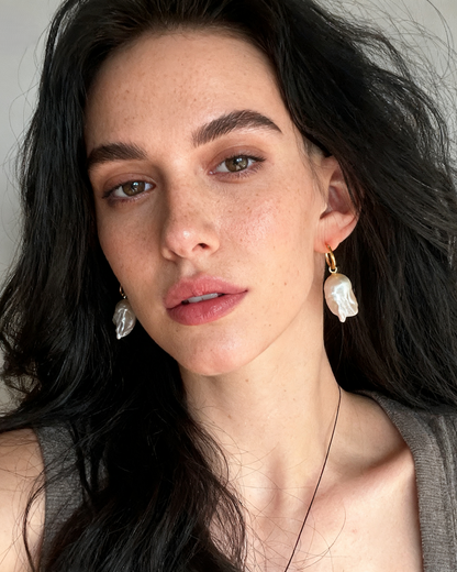 Woman wearing earrings with a neutral background