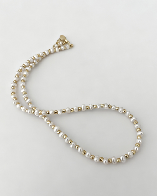 Pearl necklace on a light gray background